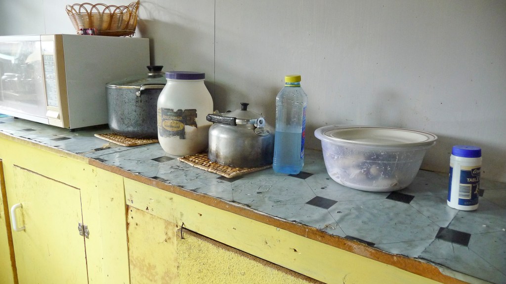 Kitchen counter with (from left to right) large pot with rice, sugar, teapot, and a bowl with boiled bananas with coconut cream (fa'i fa'alifu). Photo by Jessica Hardin.